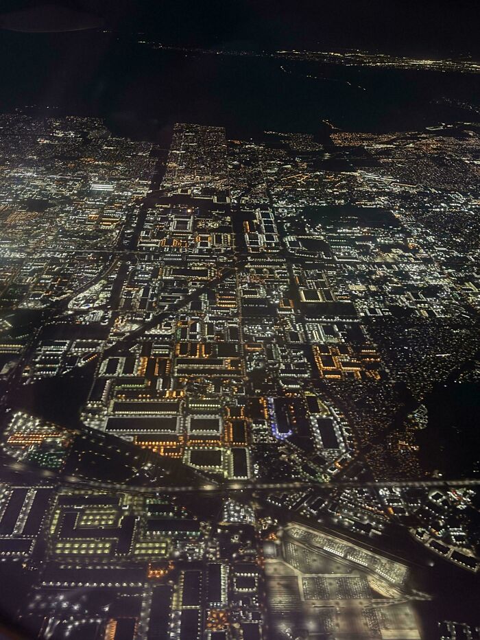 Aerial view of a city at night, showcasing fascinating illuminated grid patterns in the sprawling urban landscape.