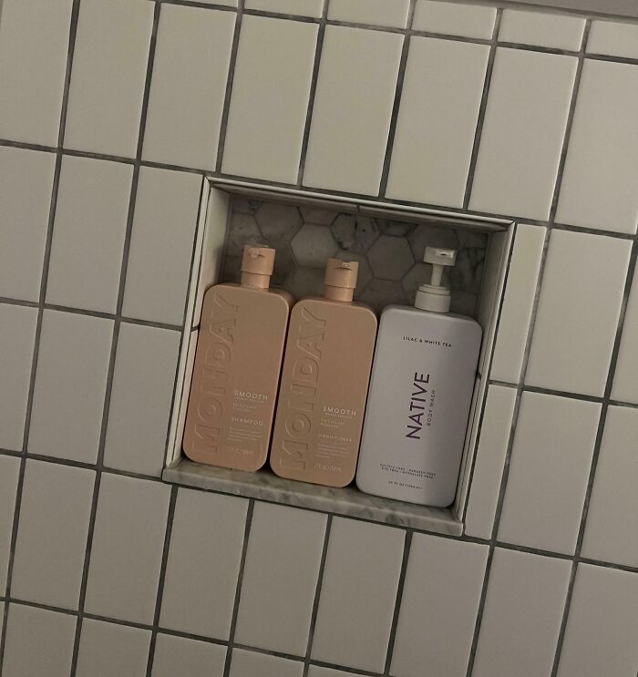 Perfect fit of shampoo and conditioner bottles in a small tiled shower niche.