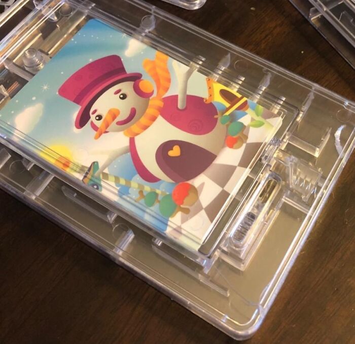 Gift card with a colorful snowman design in clear plastic packaging.