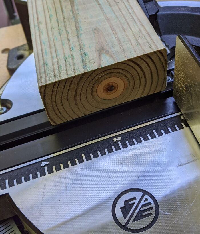 Close-up of a wooden board on a saw table showing precise measurement markings. Fascinating construction tool details.