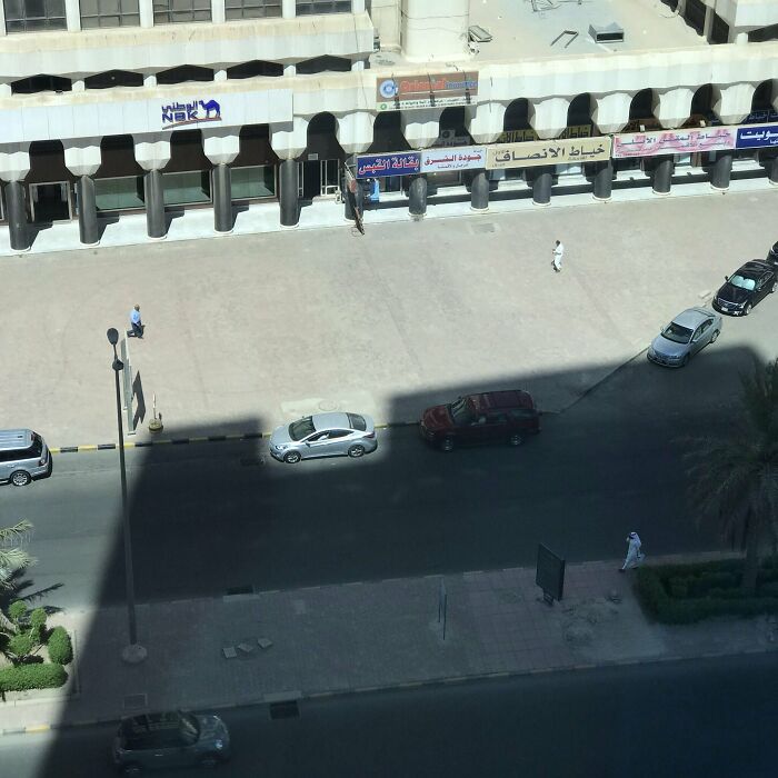 Cars parked perfectly along the street, showcasing satisfying perfect fit precision in alignment and spacing.