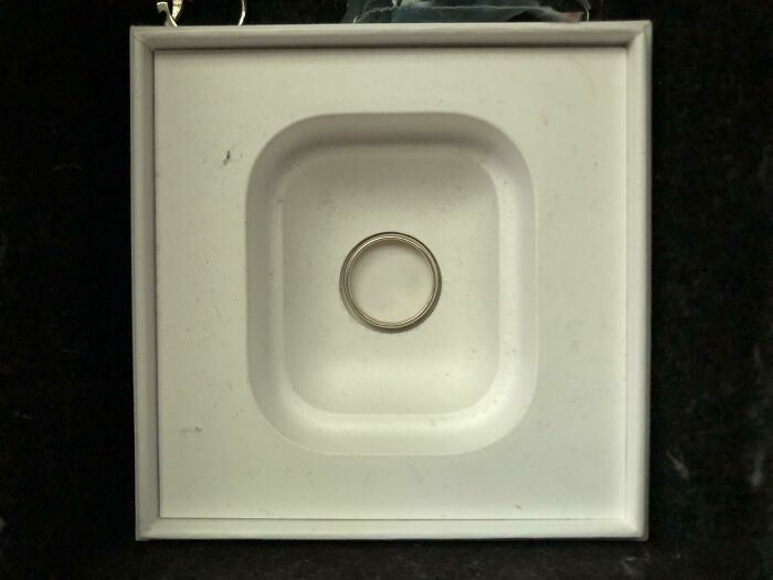 Perfectly fitting metal ring snugly placed inside a square white holder.