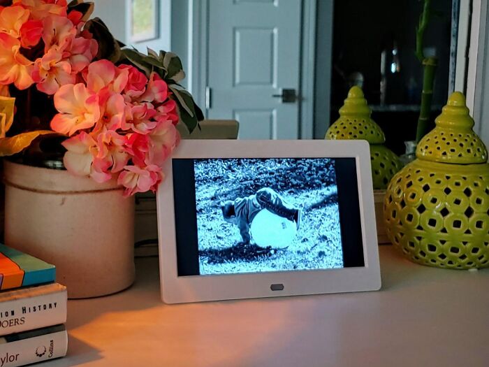 Digital photo frame on desk with flowers, ideal gifts for your mom.