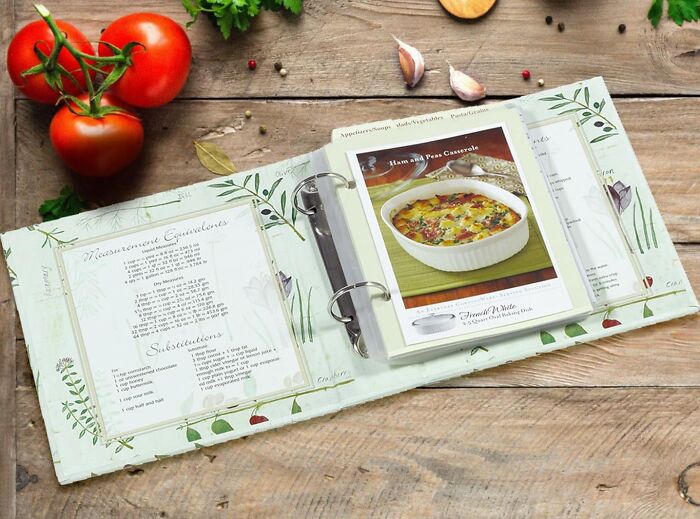 Recipe binder on a wooden table with tomatoes, ideal gift for your mom.