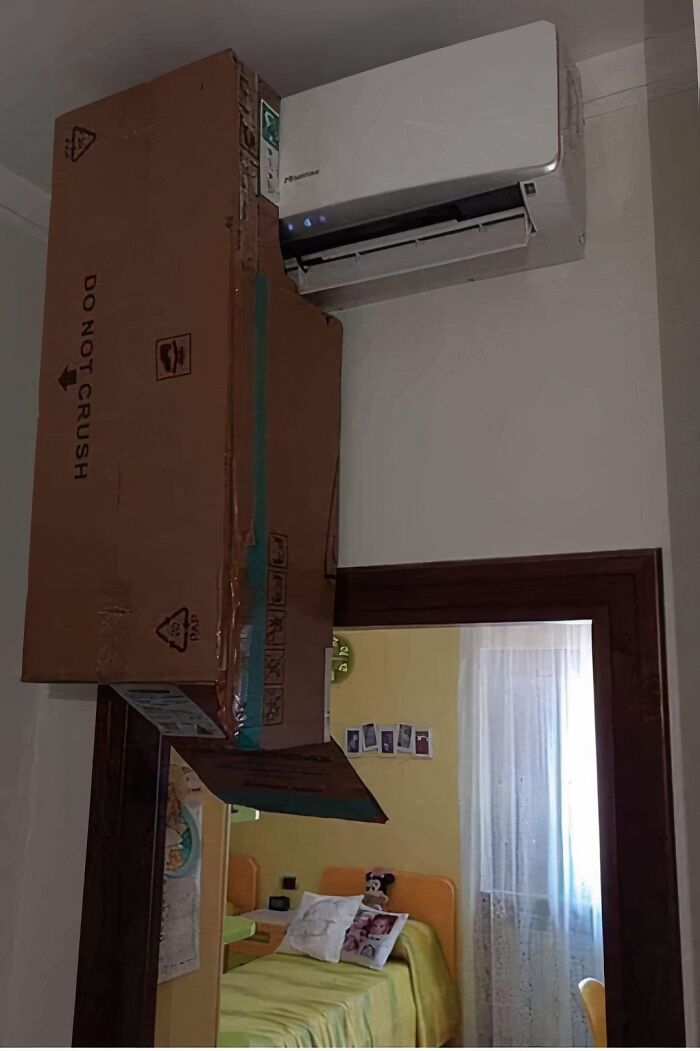 Cardboard box poorly installed under air conditioner, highlighting engineer mistakes.