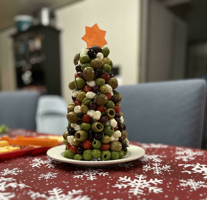 Christmas snack food idea: olive and cheese Christmas tree on a festive table.