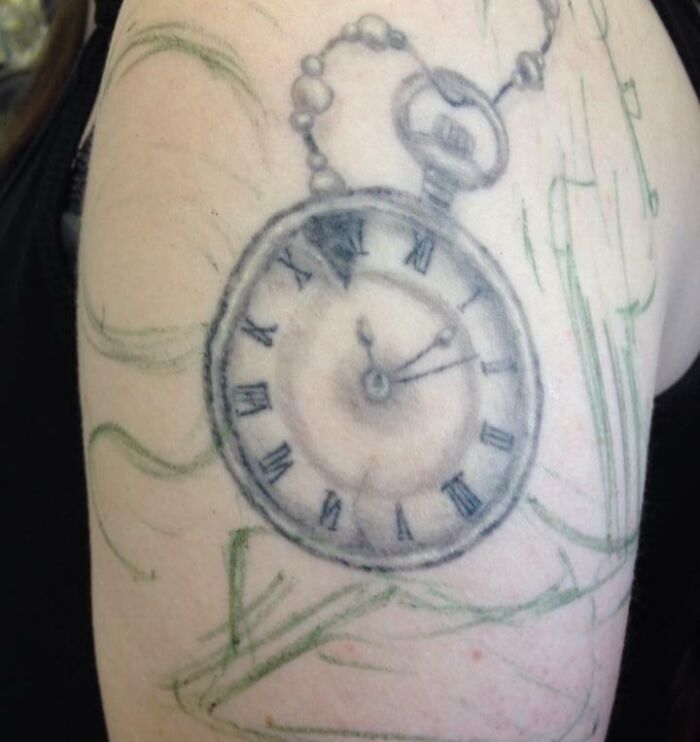 Epic tattoo fail of a clock with faded lines and uneven shading on an arm.