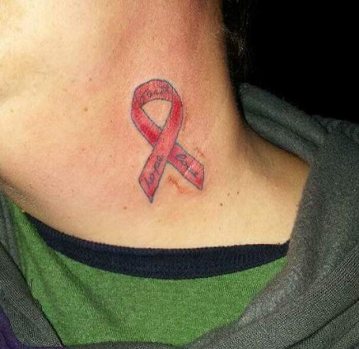 Epic tattoo fail of a poorly executed red ribbon on a neck.