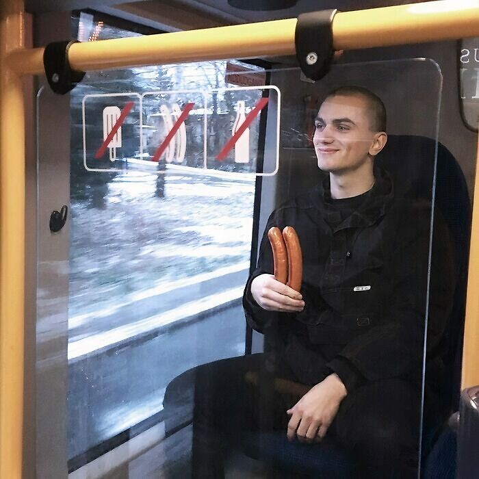 Person smiling while holding sausages on a bus; example of cursed image content from a popular Instagram page.