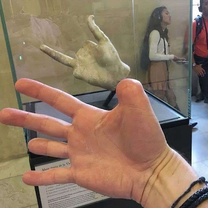 A hand mimicking a museum sculpture gesture, creating a cursed image effect.