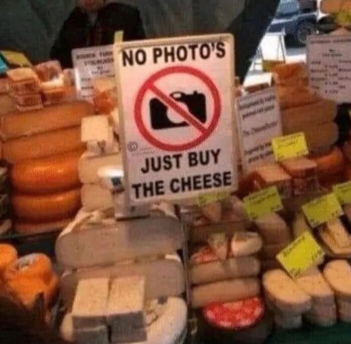 Cursed image of a cheese shop with a sign reading "No Photos, Just Buy the Cheese."