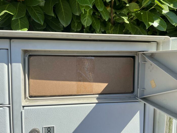 Package perfectly fitting into a mailbox slot under sunlight.