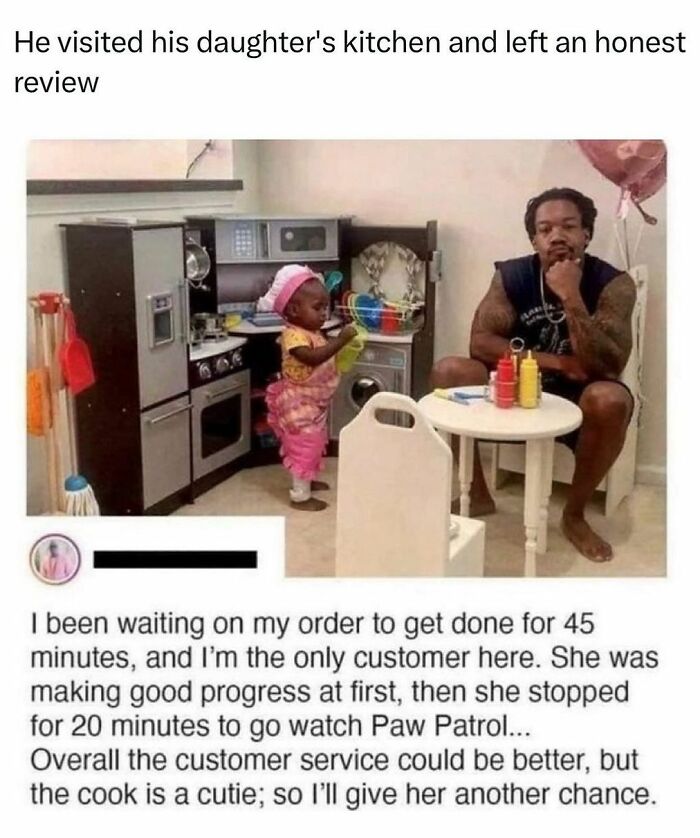 Father and daughter in a toy kitchen setup; wholesome kindness post about patience and humor in parenting.