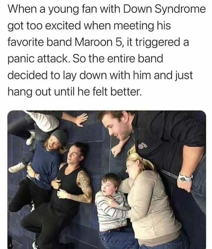 Band members and a young fan with Down Syndrome lying on the floor, showcasing wholesome kindness.