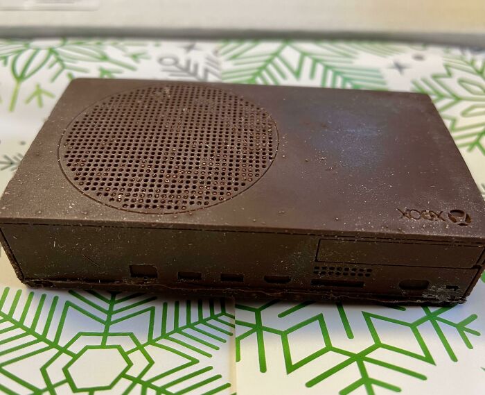 Chocolate Xbox console on a festive Christmas-patterned background, representing wholesome Christmas posts.