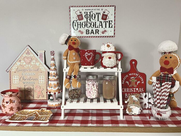 Christmas decorating ideas with gingerbread figures, festive mugs, and holiday treats on a red checkered tablecloth.