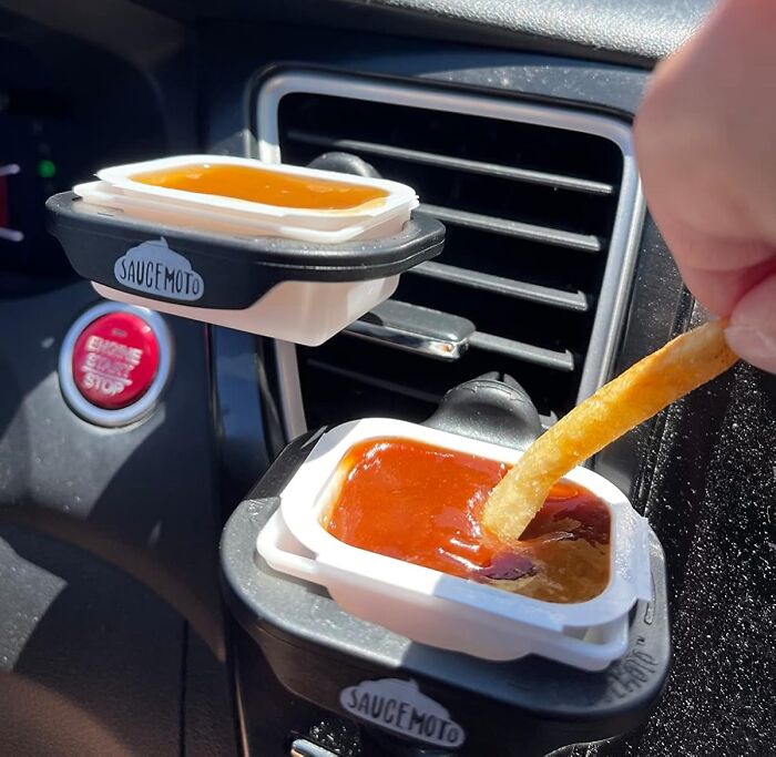 Car vent sauce holders with dips and a fry.