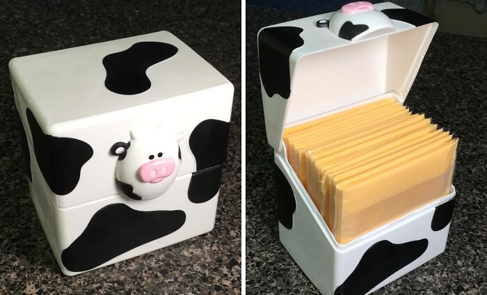 Cow-patterned box with cheese slices inside on a countertop; quirky kitchen accessory.