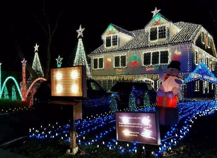 House decorated with Christmas lights and inflatable snowman, featuring trees and stars for festive decorating ideas.