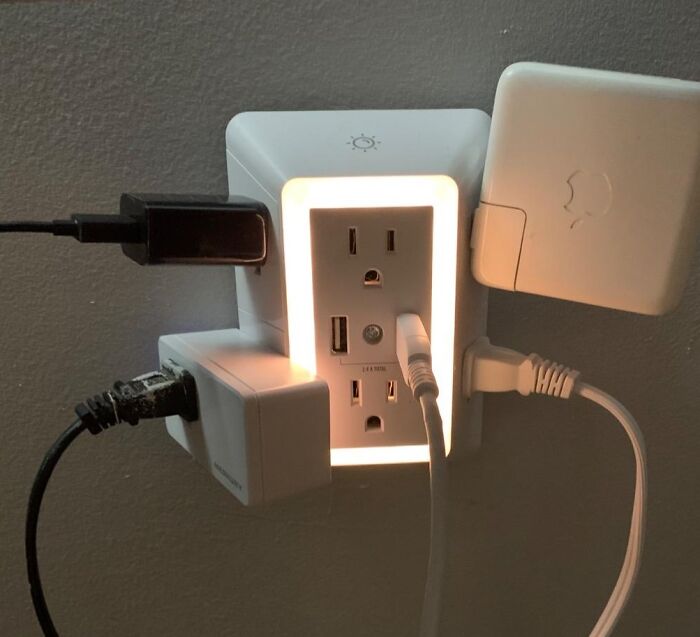 Illuminated multi-plug adapter with multiple devices connected, showcasing clever inventions for reducing frustration.