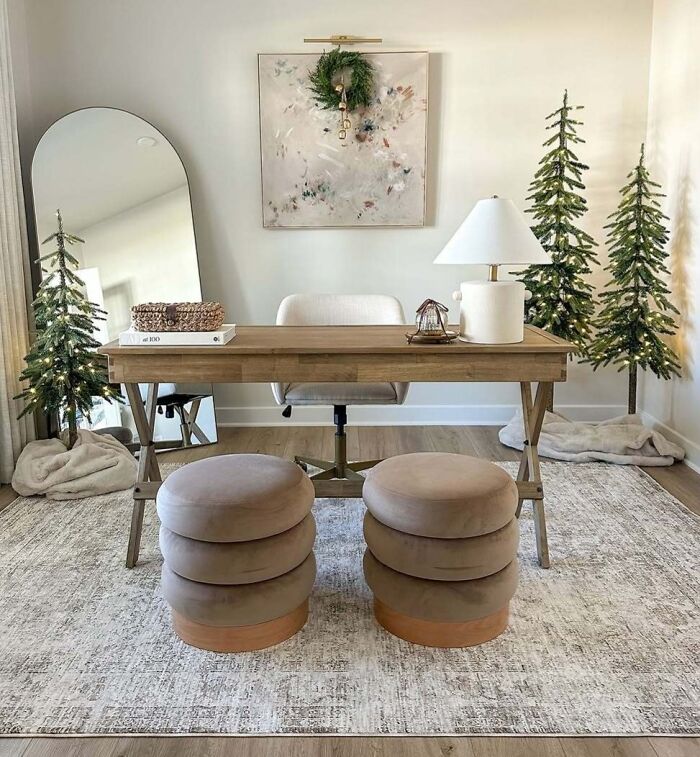 Home office with Christmas-decorating-ideas, featuring a wooden desk, small Christmas trees, and festive wreath.