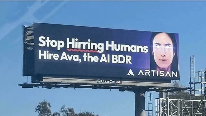 Billboard showing a dystopian society message: "Stop Hiring Humans. Hire Ava, the AI BDR" with a spelling error.