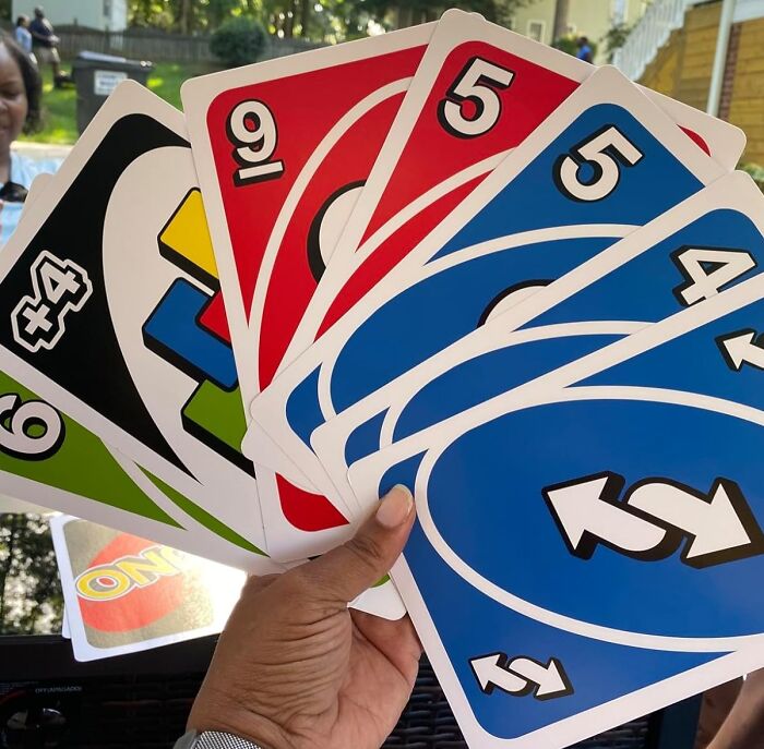 Hand holding oversized UNO cards, perfect for White Elephant Gifts.