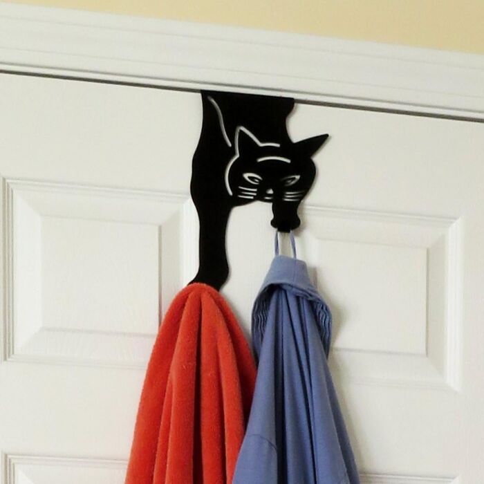 Cat-shaped over-the-door hook, perfect white elephant gift, holding red and blue towels.