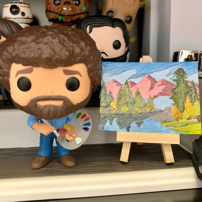 Fun white elephant gift idea: a small artist figurine with a colorful landscape painting on an easel.