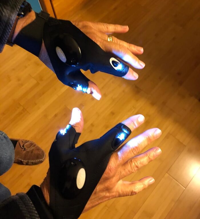 Hands wearing LED light gloves, a fun option for white elephant gifts.