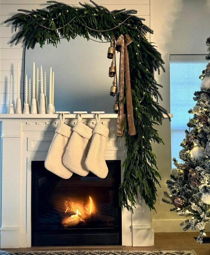 Cozy fireplace with Christmas decorations, stockings, and a decorated tree for holiday inspiration.