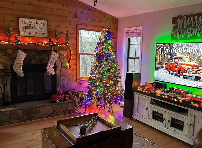 Festive living room with a Christmas tree, stockings by the fireplace, and colorful lights, showcasing Christmas decorating ideas.