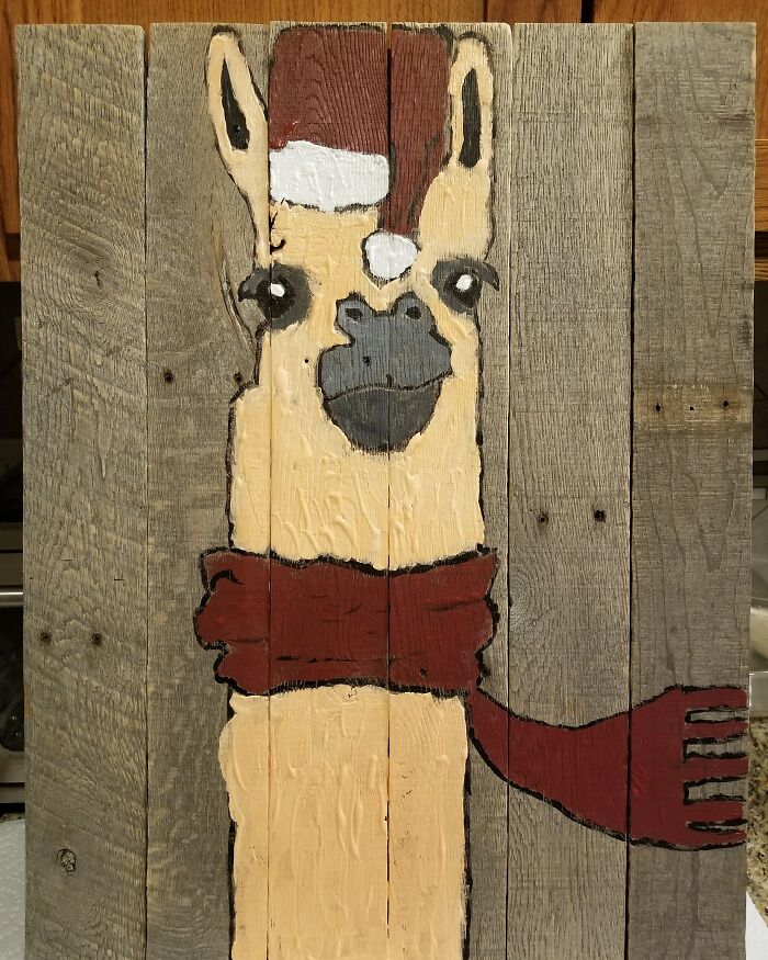 Llama in Santa hat and red scarf painted on rustic wooden planks, capturing a wholesome Christmas theme.