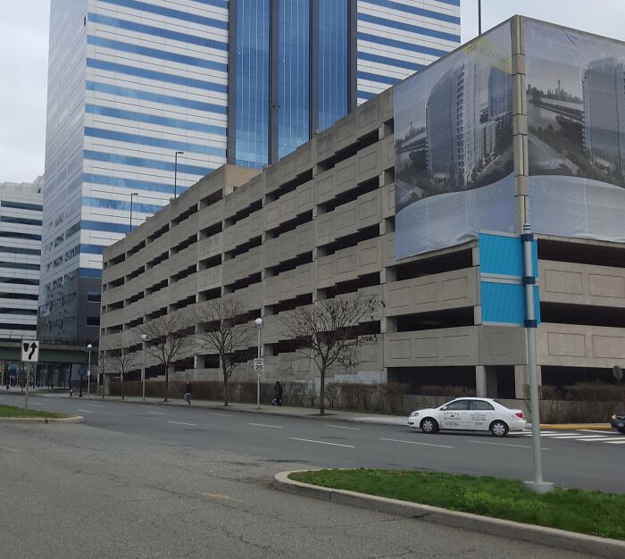 Urban parking garage and skyscraper resembling a videogame scene.