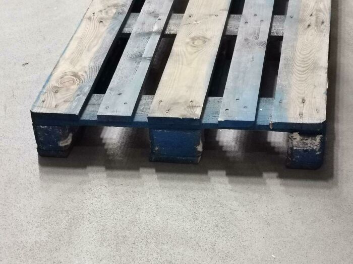 Wooden pallet on concrete floor resembles videogame graphics.