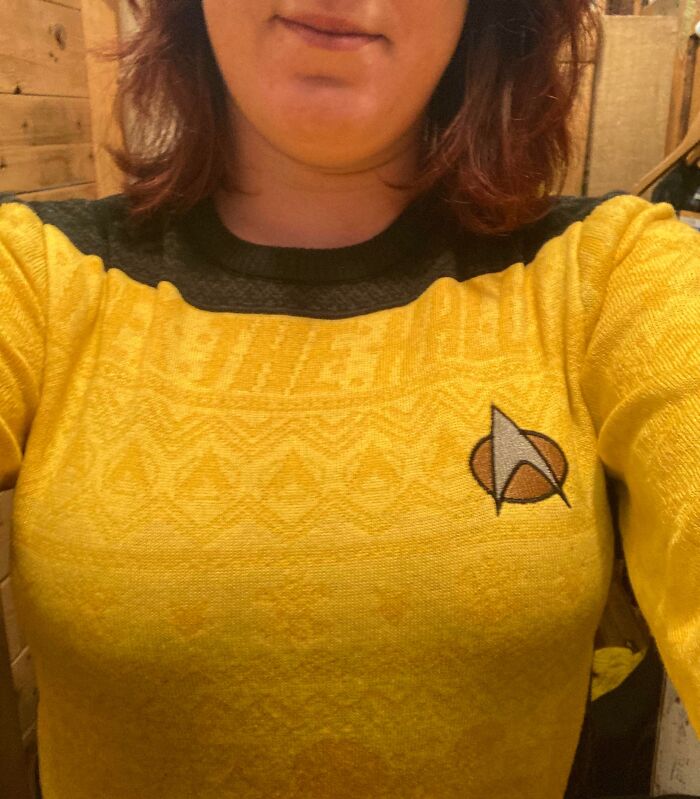 Person wearing a yellow Starfleet sweater, capturing a warm and wholesome moment.