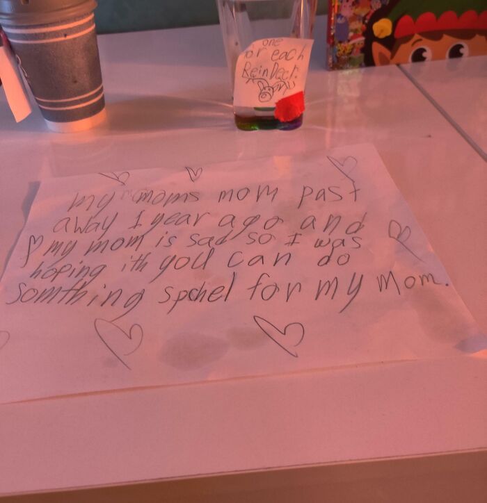 Child's handwritten note for Santa with hearts, a Christmas cup, and reindeer snacks on a table. Wholesome Christmas scene.