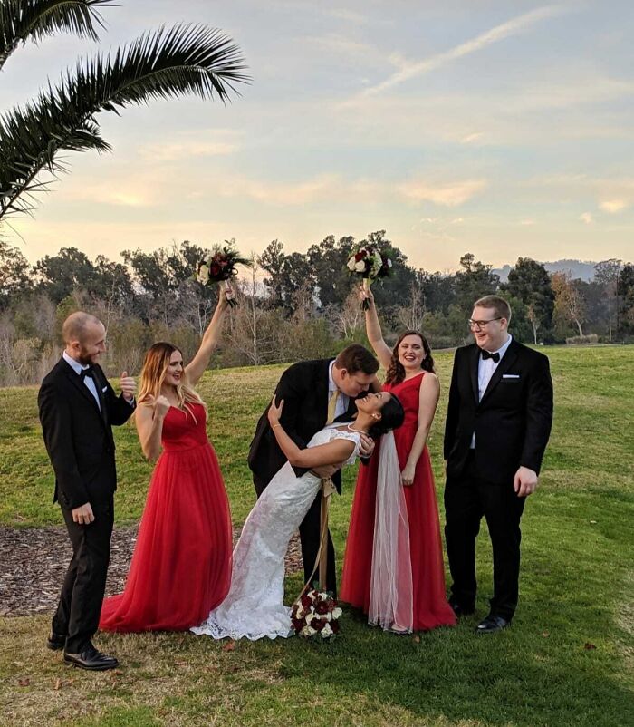 Elegant wedding party celebrating with a joyful kiss on a festive day.