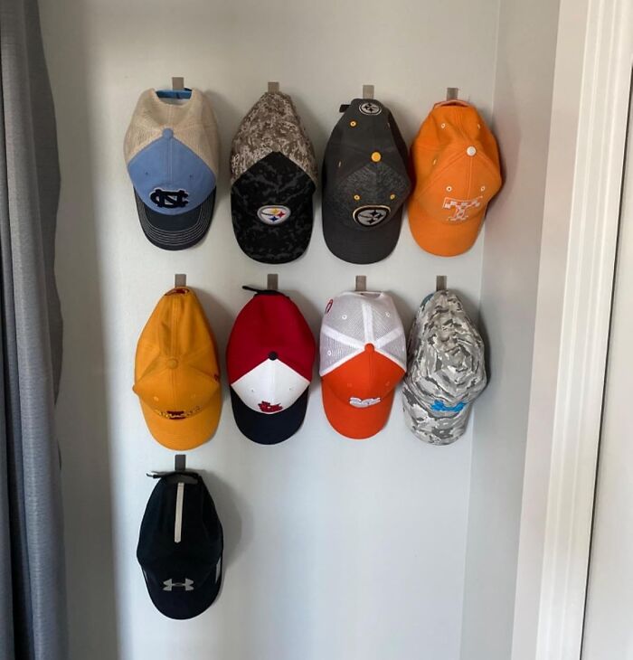 Wall-mounted hat organizer displaying nine caps for decluttering and organizing your home.