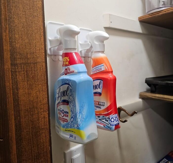 Cleaning products neatly organized on wall hooks in a pantry, illustrating effective declutter strategies for 2024.