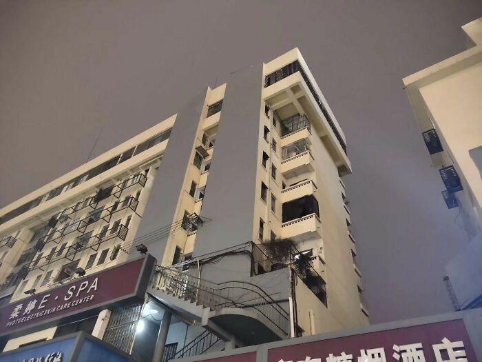 A tall building at night resembles videogame graphics with dramatic lighting.