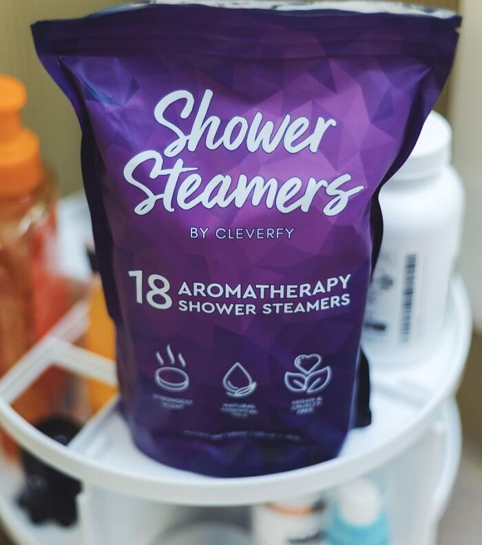 Purple packaging of shower steamers on a bathroom shelf, part of a fun subscription box.