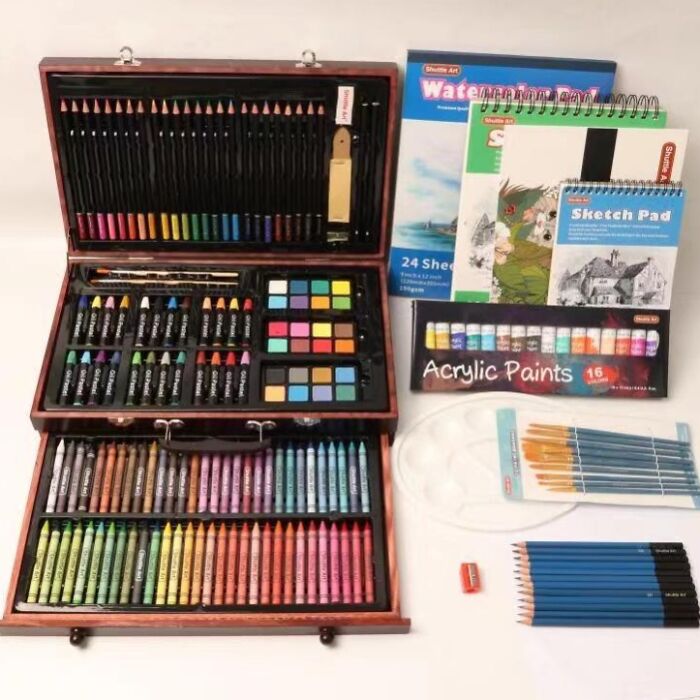 Art supply subscription box with acrylic paints, colored pencils, sketch pads, and brushes.