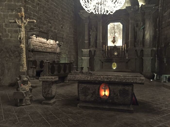 A medieval-style stone crypt with a chandelier, resembling a videogame setting.