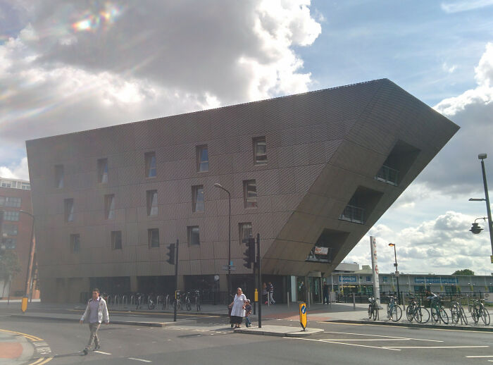 Futuristic building with geometric design, resembling videogame architecture in an urban setting.