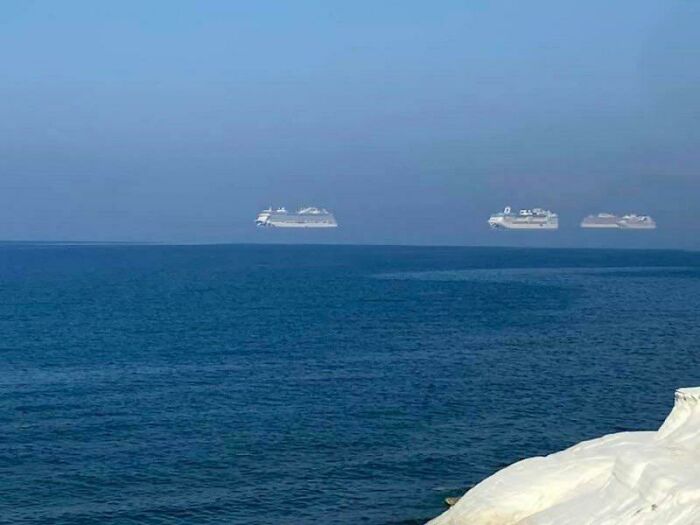 Cruise ships on the horizon with an optical illusion making them appear as bad renders over the ocean.