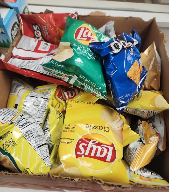 Box of assorted potato chip bags, showcasing popular snacks and their colorful packaging.