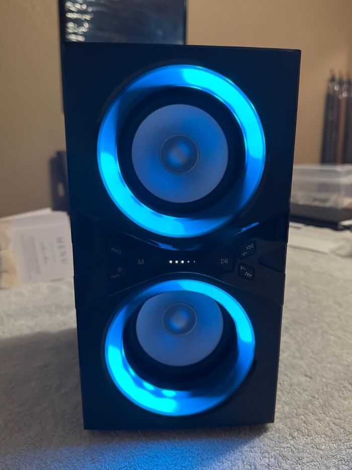 A speaker with two illuminated blue rings, showcasing nye hosting tips for audio quality enhancement.