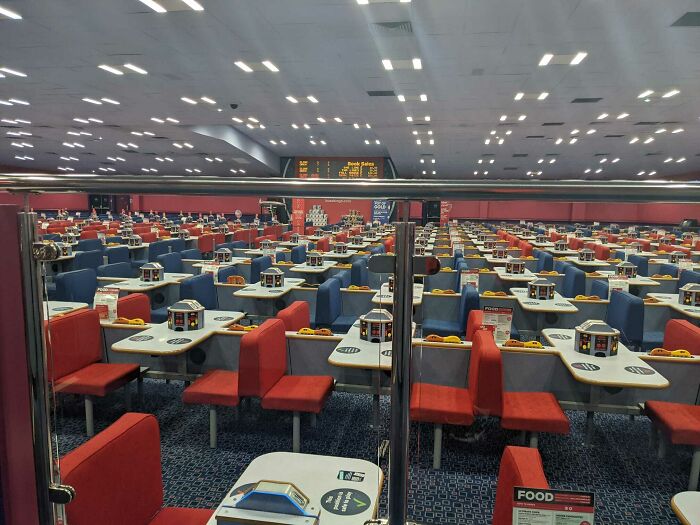 Empty bingo hall features vibrant red and blue seats, resembling a scene from a videogame.