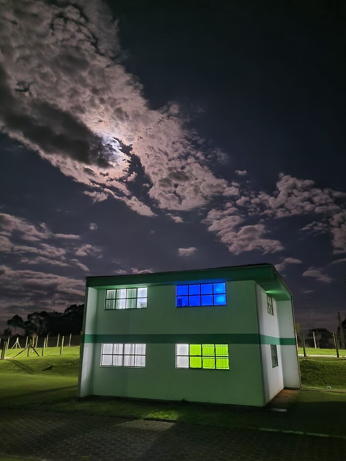 A building under a night sky, illuminated by moonlight, resembling a scene from a videogame.